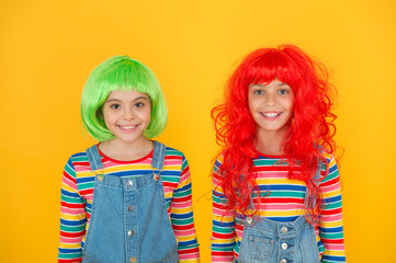 Sisters having fun. Pigment dye hair. Freedom for expression. Fantasy hair trend. Semi permanent color cream. Colored clip in hair extensions. Change color. Kids girls with vibrant hairstyle