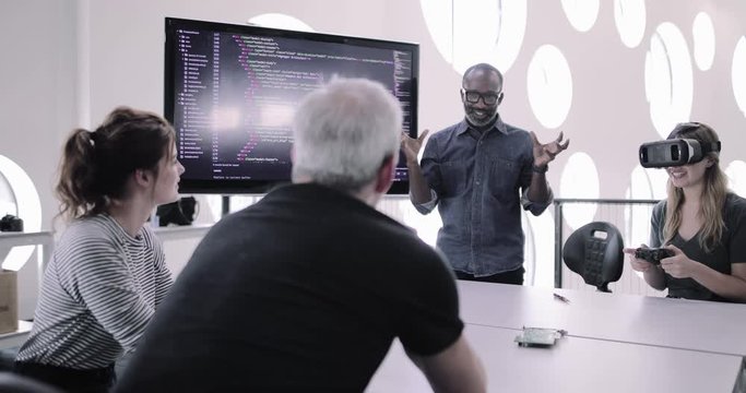 African American male game designer leading a meeting