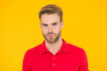 Strict glance. Handsome man unshaven face and stylish hair. Caucasian man on yellow background....