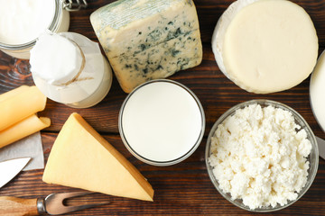 Different dairy products on wooden background, top view