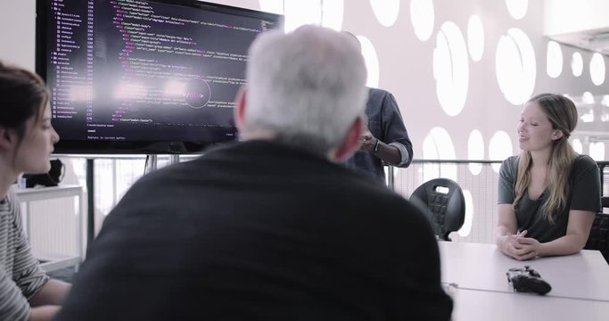 African American male game designer leading a meeting