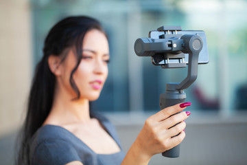Blogger girl shoots a video about traveling on an electronic stabilizer.
