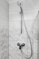 Modern, grey style tiles and shower with shower head.