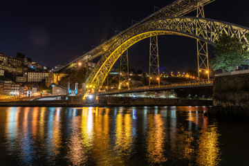 Fototapeta na wymiar Night illuminated metal arch bridge of Ponte Luis I from the banks of the river Douro