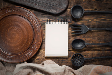 Food menu or product list mock up. Blank pages notepad and empty plate on a wooden kitchen table background.