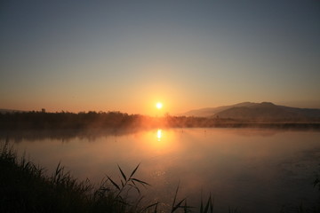 Fototapeta na wymiar sunrise with fog on the lake