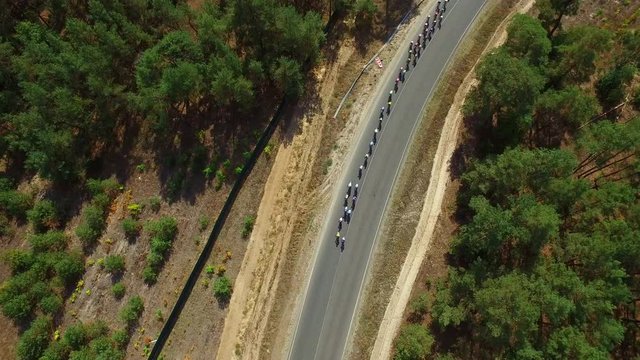 Cycling race on country road. Drone view group cyclists racing highway