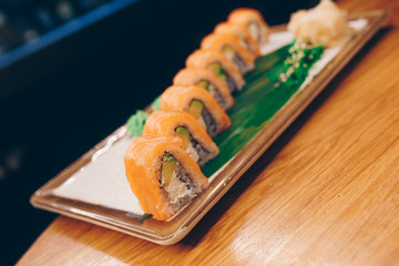Sushi Smoked Philly plateau buffet in night dining restaurant flat lay. Delicious Philadelphia salmon flesh seaweed and ginger. Sushi rolls served  in a restaurant. The norwegian salmon and Fish.