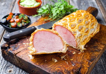 Gebackenes Kassler Schweinerückensteak in Blätterteig Mantel am Stück und aufgeschnitten mit...