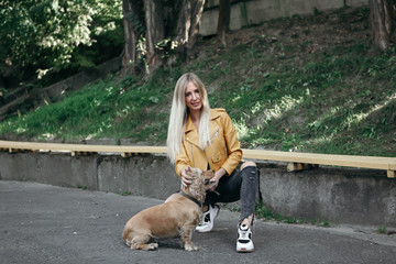 Young girl with dog walks in the park and enjoys the beautiful summer day.