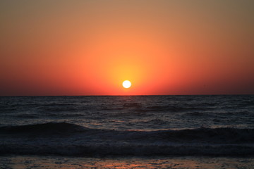 a sunrise at the seashore in red colors