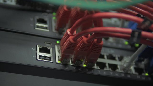 server patch panel with red Ethernet wires.