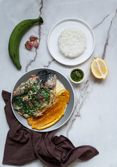 Colombian and Mexican, Venezuela food - trucha al ajillo -  river trout, served with a large,fried plantain, patacon and garlic sauce