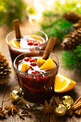 Christmas mulled red wine with spices, cranberry and oranges. Traditional hot drink or beverage, festive cocktail at Xmas or New Year with decorations