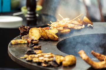 Street food cooking on open fire place.