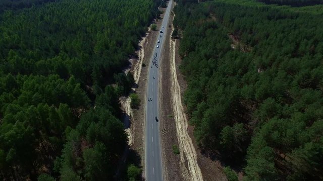 Drone view bicyclists group riding at countryside highway on bike ride