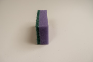 Circular household sponge in different colors for washing dishes on a white background