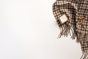 Warm scarf and candle, isolated on white background. Flat lay.