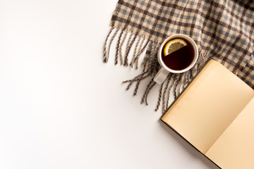 Autumn, cozy composition. Cup of tea, warm scarf, book, isolated on white background. Flat lay.