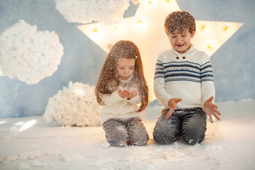 happy cute children, brother and sister in a snowy New Year party waiting for a merry Christmas