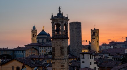 Bergamo at sunset in the old city with towers and bell tower,