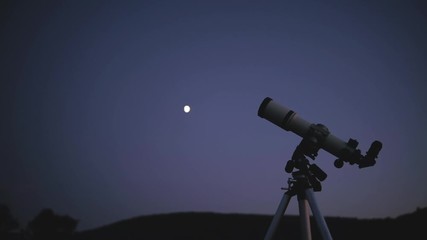 Silhouette of a telescope with evening sky in the background.