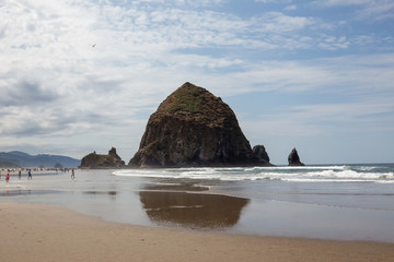 Fototapeta na wymiar Cannon Beach, Oregon coast: the famous Haystack Rock reflects itself in the water