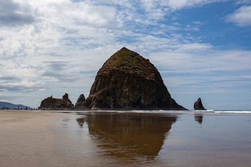 Cannon Beach, Oregon coast: the famous Haystack Rock reflects itself in the water