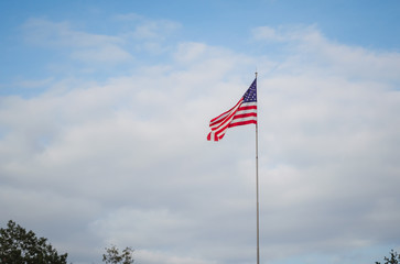 USA flag trembling at the wind against blue sky
