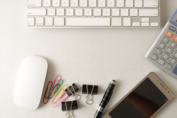 Top view of office stationeries over a grey background.