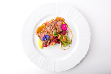 Tender pork in a sauce with artichoke mash, berries and flowers. Banquet festive dishes. Fine dining restaurant menu. White background.