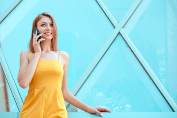 happy young woman smiling and talking on a smartphone near Louvre
