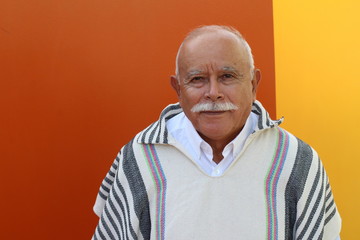 Legit Hispanic senior man wearing a ruana 