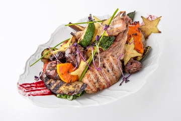 Roast pork or lamb with grilled vegetables and exotic fruits. Banquet festive dishes. Fine dining restaurant menu. White background.