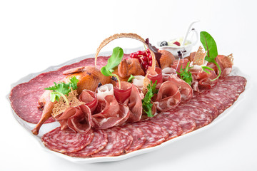 Salami, sliced ham, smoked quail, prosciutto, sausage. Meat antipasto platter. Banquet festive dishes. Gourmet restaurant menu. White background.