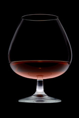 glass with cognac on a black background