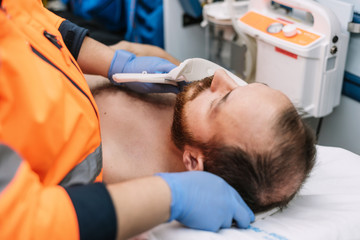 Paramedic putting a cervical collar to a patient in the ambulance . © herraez