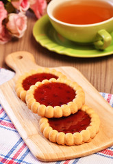 Raspberry jam tarts on wooden board 