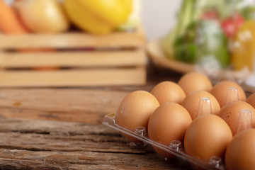 Eggs in the plastic on the wooden table