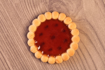 Raspberry jam tarts on wooden board 