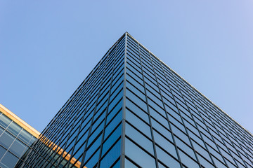 Fototapeta na wymiar perfect geometry of blue facade of scyscraper mirrors the sky triangle pyramid