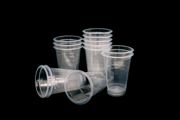 Plastic drinking cups are beautifully arranged on a black background.
