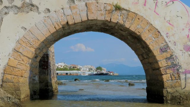 Touristic city, island. Euboea, Greece. City of Chalkida. Traveling concept. City and seascape with beautiful color of water. Stone bridge through Mediterranean sea with cityscape on background.