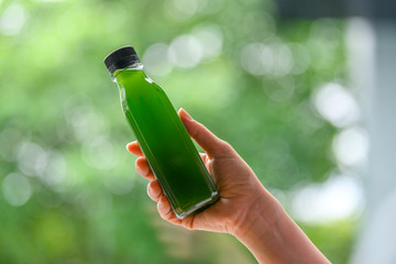 Healthy fruit juice in clear plastic bottles, the background is a green garden and bokeh.