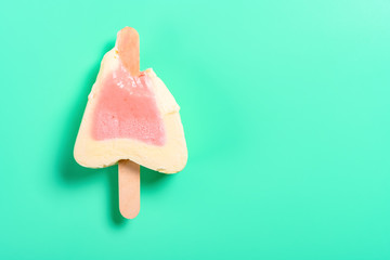 top view strawberry flavor popsicle with some bites on a green background
