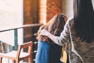 A woman comforting and giving encouragement to her sad friend