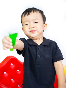 ฺBaby boy in black shait is eating delicious jelly
