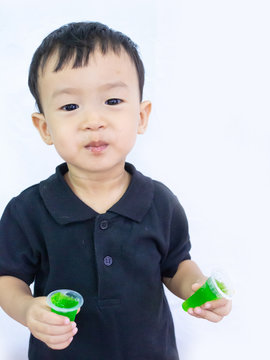 ฺBaby boy in black shait is eating delicious jelly