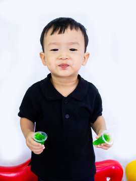 ฺBaby boy in black shait is eating delicious jelly