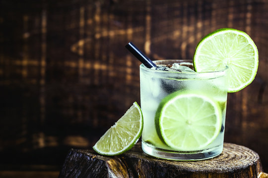 Fresh summer alcoholic caipirinha on a rustic wooden table, party drinks cocktail background. Space for text. Brazilian summer cold drink.